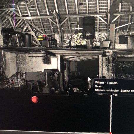 3D Laserscanning und Punktwolkenerstellung für die weitere Erstellung von CAD-Pläne Dunkle Innenaufnahme eines Raums mit Regalen und einer roten Kugel im Vordergrund.